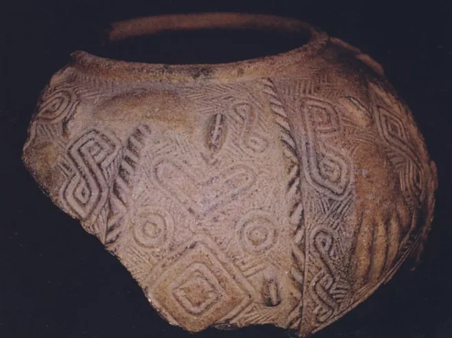 A large, broken clay pot on black, decorated with raised spirals, concentric circles, diamonds and rope-like bands.