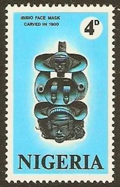 A Nigerian 4d postage stamp in pale blue showing a dark carved mask, labelled “Ibibio face mask carved in 1900”.